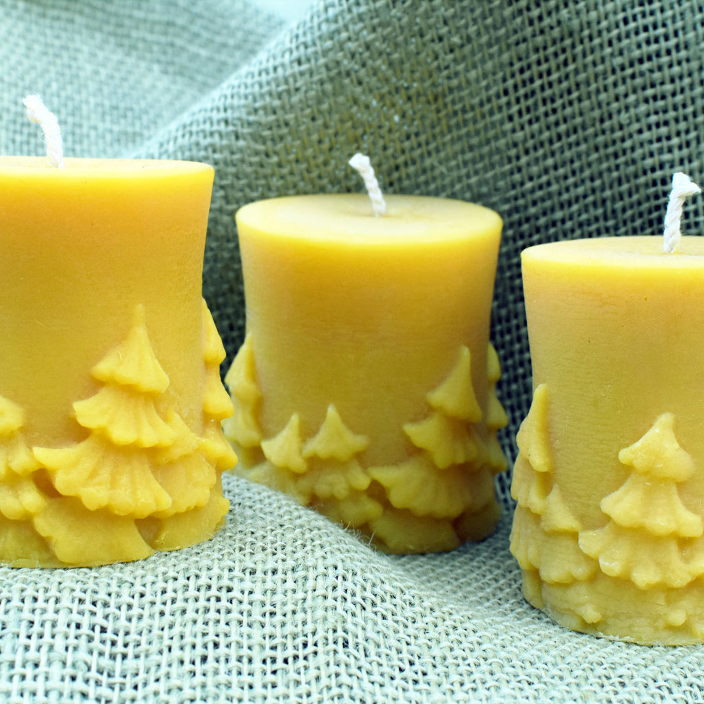Pillar beeswax candle with a forest design on a textured backgournd